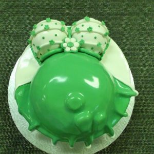 Gâteau en pâte de sucre en forme de ventre de maman portant une robe verte, décorée de jolies fleurs vertes. Parfait pour un shower de bébé.