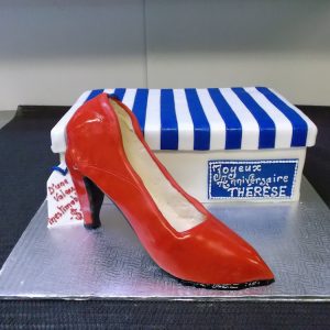 Gâteau en forme de boîte a soulier et d'escarpin rouge. Belle chaussure à talon-haut en pâte de sucre. Fait sur mesure, pour plus d'information contactez-nous.