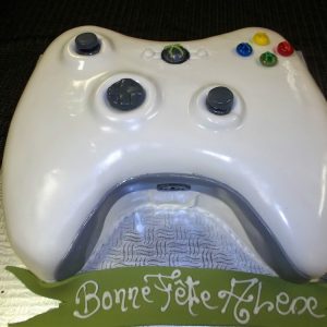 Gâteau en forme de manette de Xbox fait sur mesure, parfait pour anniversaire de «gamer». Manette blanche faite en pâte de sucre. Fait sur mesure, pour plus d'information contactez-nous.