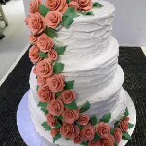 Gâteau de mariage fait sur mesure, 4 étages. Imitation de roses grimpant le long d'un mur de brique. Fait sur mesure, pour plus d'information contactez-nous.
