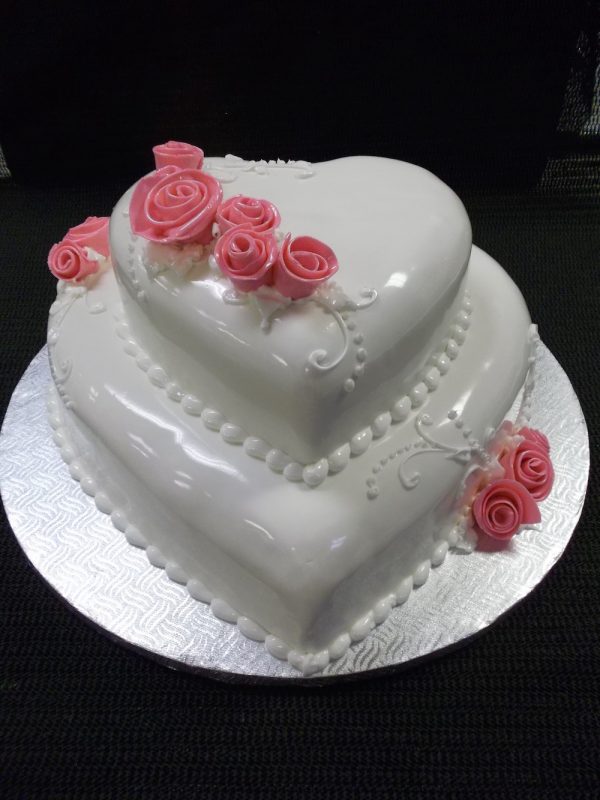 Gâteau de mariage en forme de coeur fait sur mesure. Avec de jolie roses faites en pâte de sucre. Fait sur mesure, pour plus d'information contactez-nous.
