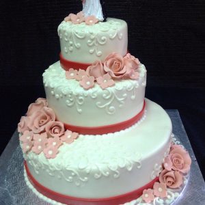 Gâteau de mariage fait sur mesure avec fond blanc et beaucoup de fleurs. Silouhettes des époux sur au sommet d'un gâteau 3 étages en pâte de sucre. Fait sur mesure, pour plus d'information contactez-nous.